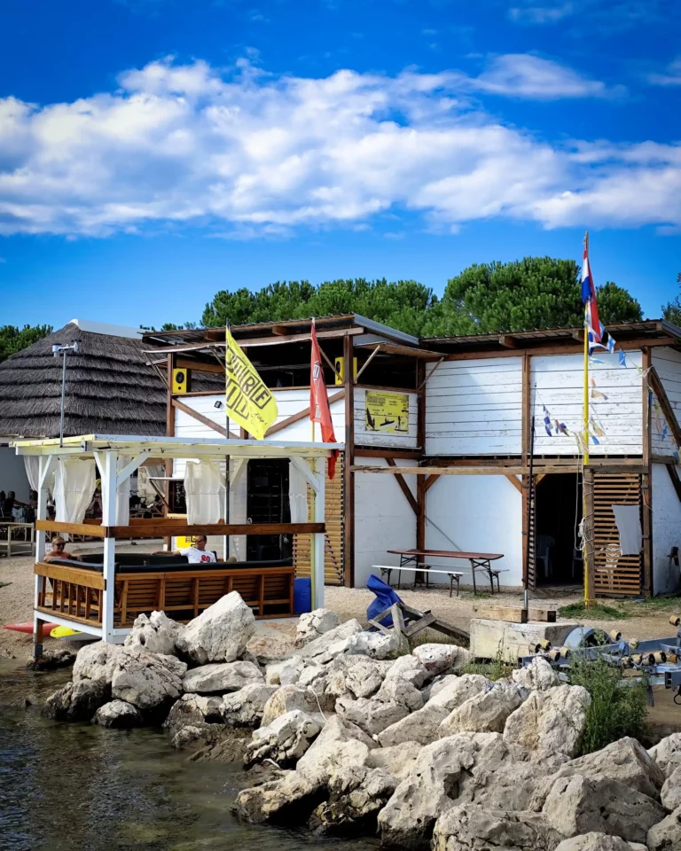 Drveni beach bar uz more s zastavama